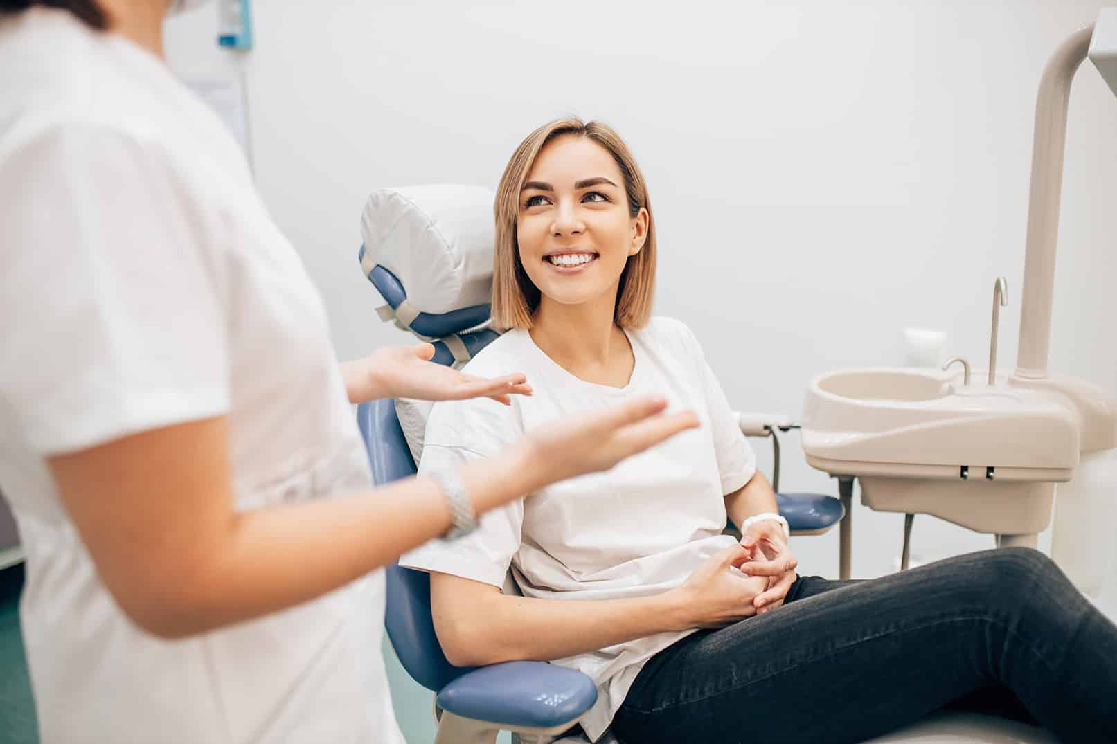 female dental patient talking withdr cox about cosmetic dental treatments for her chipped tooth